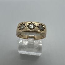 A 9ct yellow gold three stone diamond signet ring. Featuring three gypsy set, round brilliant cut