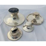 A group of four sterling silver weighted inkwells. Featuring a circular inkwell with a pique work