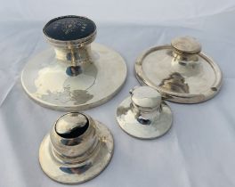 A group of four sterling silver weighted inkwells. Featuring a circular inkwell with a pique work