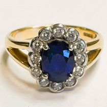 An oval sapphire and diamond cluster 18ct gold ring. Sapphire approximately 2.69ct. Four claw set