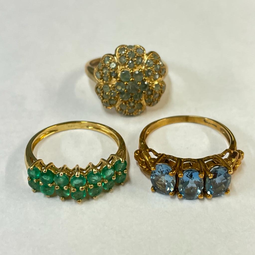 A collection of three 9ct yellow gold gem set rings. Featuring a flower form chrysoberyl ring, a