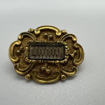 A 19th century mourning brooch, featuring a central panel of woven dark hair. Uninscribed and