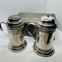 A collection of George V silver comprising a pair of handled table salt and pepper pots and an