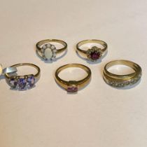 A group of five 9ct gold gem set rings. Featuring a tanzanite set band ring; a pear drop Tanzanite