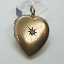 An antique heart shaped "Front and back 9ct" locket, set with a gypsy set old mine cut diamond (