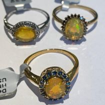 Three Ethiopian opal 9ct gold dress rings Featuring an opal and red diamond ring; an "east to