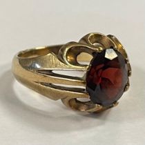 A 9ct yellow gold claw set garnet ring. Featuring an oval mixed cut garnet measuring approximately