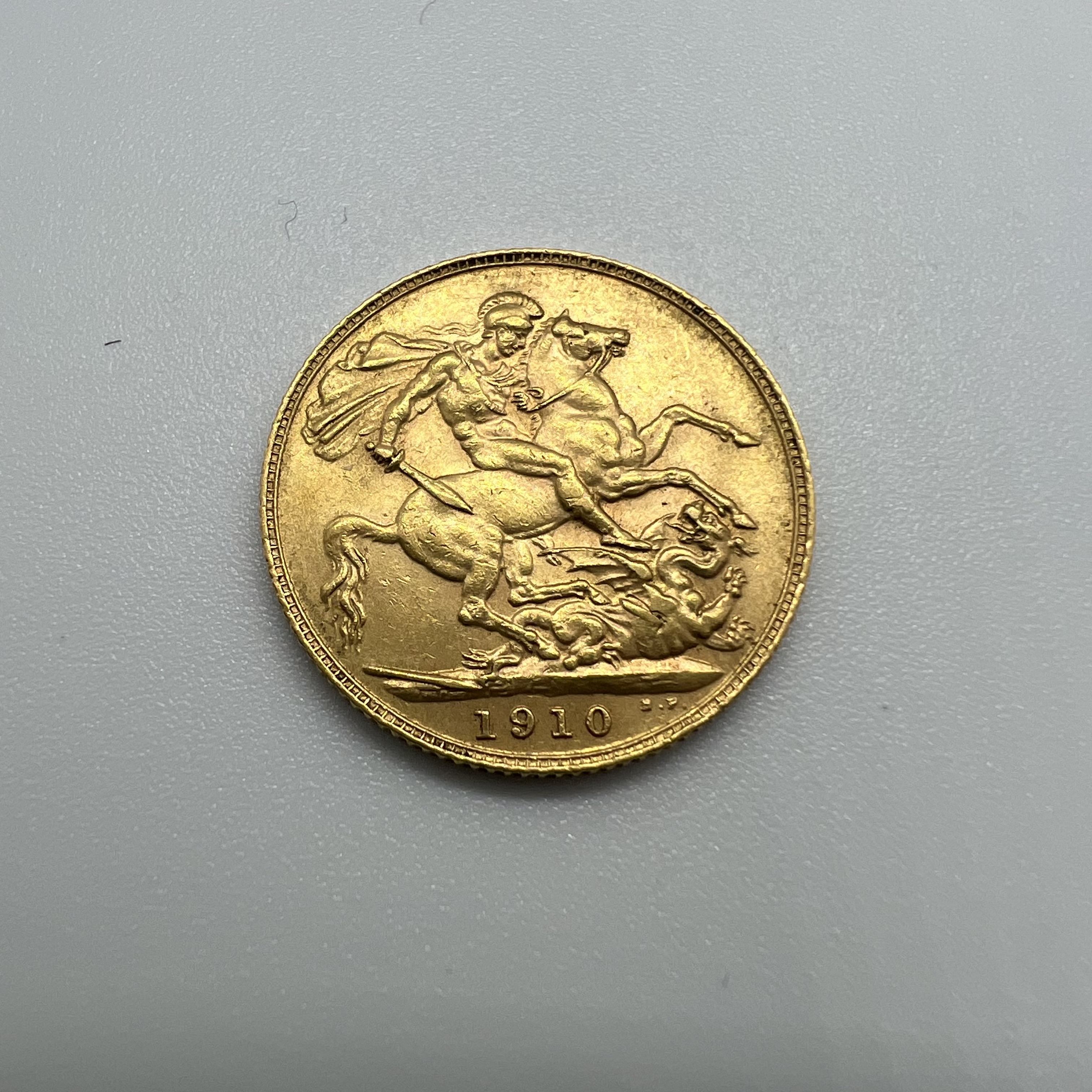 An Edward VII gold sovereign coin, dated 1910.