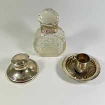 A silver rimmed cologne bottle, approx 14cm tall. A silver capstom inkwell and a weighted silver