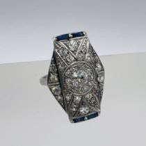 An Art Deco diamond and sapphire panel ring. Featuring 35 old mine cut diamonds and four baguette