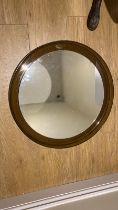 A Guzzini smoked plastic frame circular wall mirror.  56cm diameter.  Generally good condition