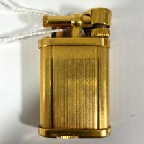 A gold plated Dunhill unique gas lighter number 357623.  50mm x 30mm.  Some small dings, has not