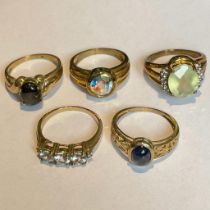 A collection of five 9ct yellow gold gem set rings. To include a cabochon sapphire ring, a black