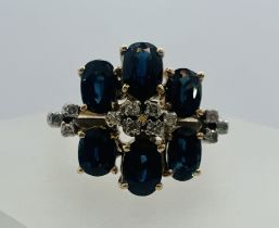 A sapphire and diamond cluster ring. Shank stamped 585. Featuring six oval mixed cut sapphires and