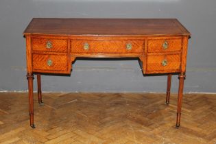 An Edwardian satinwood, crossbanded and strung dressing/ writing table, the slight bow front top