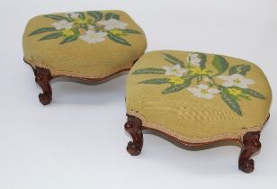A pair of Victorian rosewood framed, floral gros point upholstered footstools each raised on knuckle