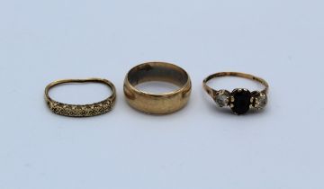 Three 9ct gold rings. A sapphire and cubic zirconia trilogy ring, size l, an as found diamond half