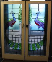 A pair of stained glass panels in Art Deco style depicting peacocks mounted in doors, 174 x 61cm