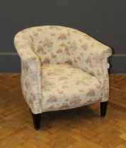 An Edwardian tub shape armchair, with floral pastel upholstery, raised on square tapering