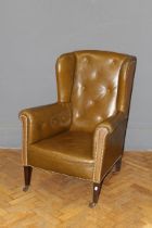 A late 19th century chocolate button hide upholstered drawing room armchair raised on square