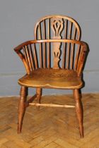 A 19th century yew and elm double hoop and stick back Windsor armchair with saddle seat, raised on