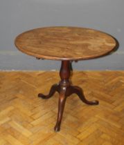 A George III mahogany tripod table, the circular snap top raised on baluster column, downswept