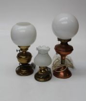 Two 19th century brass oil lamps converted to electricity, each with a globular milk glass shade,