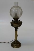 An Edwardian paraffin table lamp with brass reservoir, Corinthian column and swept panel cast