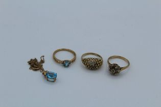 A collection of 9ct gold jewellery to include a topaz pendant and chain, two diamond set rings and a