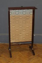 A 19th century mahogany firescreen, with later floral print rising panel and folding shelf, raised