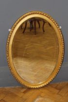 A 20th century gilt composite wall mirror with gadrooned frame and oval bevelled glass, 61 x 85cm