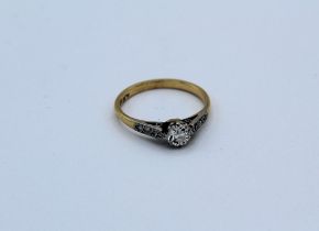 A 1930's diamond solitaire ring featuring a 1/3 carat solitaire with diamond melee set shoulders,