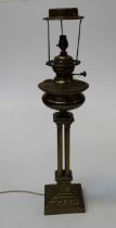 A Victorian paraffin table lamp, having a brass reservoir, four Corinthian columns and stepped