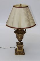 A late 20th century cast gilt metal urn form table lamp with plaited silk shade. Total height 85cm