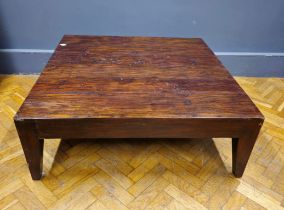 A large modern stained hardwood low table raised on square section legs, width 118cm