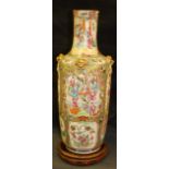 A large Cantonese famille rose vase painted with figures and birds, flowering insects reserved on