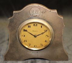 An Art Deco silver strut clock with Swiss movement, the engine turned silver case with monogram,