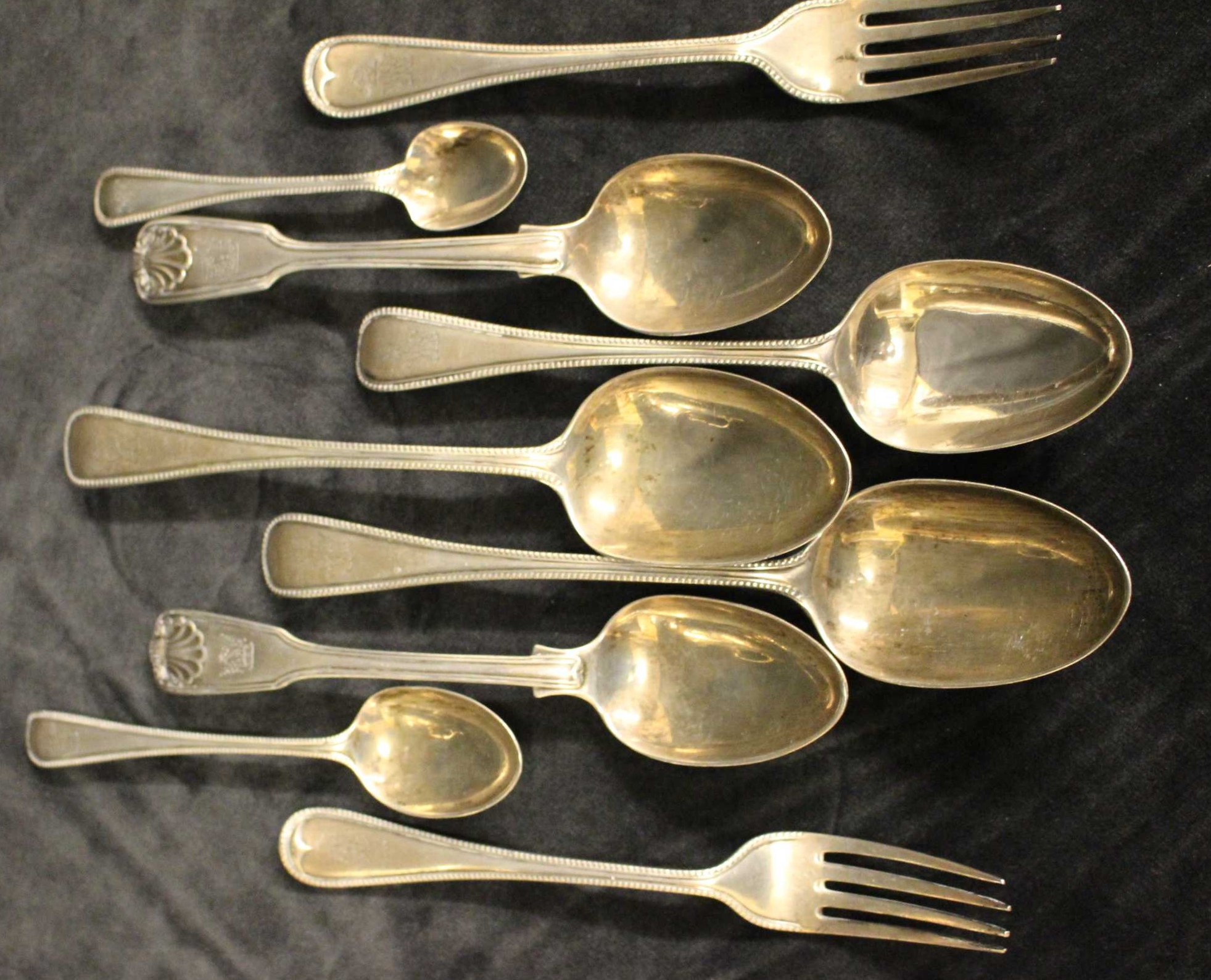A part service of Victorian silver flatware with beaded borders comprising a pair of serving spoons,