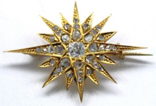 Unmarked yellow metal custom made Diamond Star Brooch.  The brooch contains a Cushion shaped Old