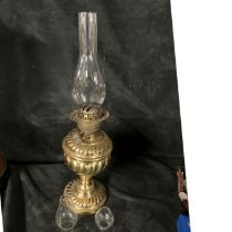 A brass oil lamp with inner flue but no outer shade.