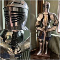 Suit of Armour.  A reproduction suit of armour standing approximately 6' high  on a 2' square plinth