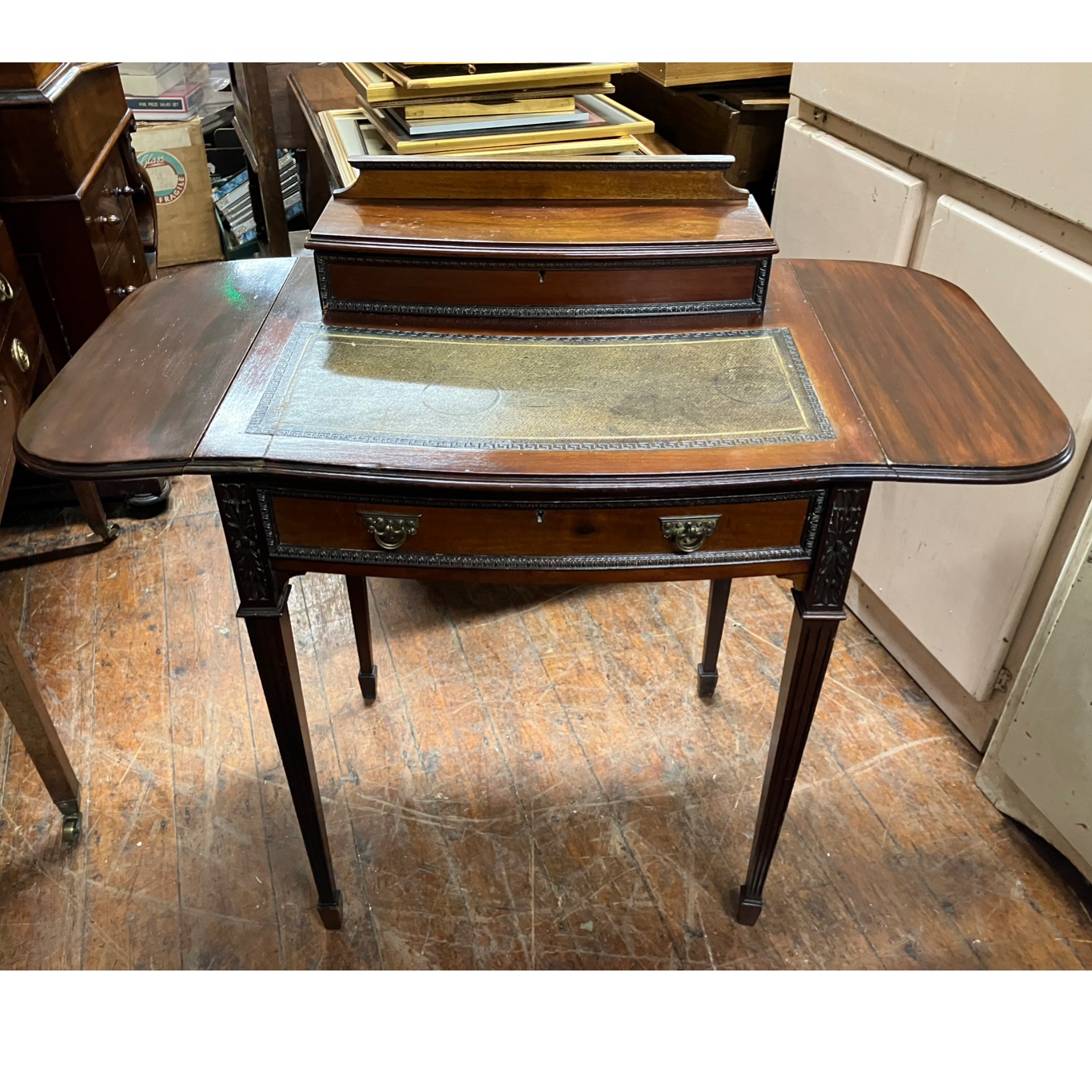 20th Century small leather topped writing desk with drop leaf extentions.