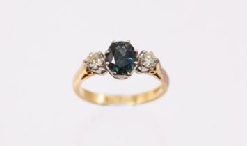 A sapphire and diamond three stone ring, comprising a central oval mixed cut sapphire approx 8 x