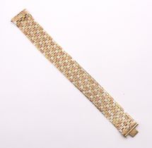 A tri colour 9ct gold wide articulated bracelet, comprising texture alternate brick style links of