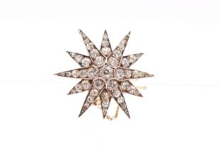 A Victorian diamond and gold star brooch, comprising grain set old European cut diamonds, the