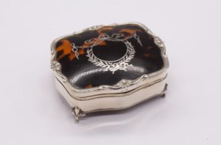 A George V silver mounted tortoiseshell shaped square jewellery box and cover, reed wavy rim above
