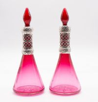 A pair of Edwardian silver mounted ruby glass conical shaped large scent bottles and stoppers, the