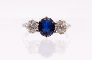 A sapphire and diamond three stone 18ct white gold ring, comprising an oval mixed cut sapphire,