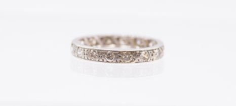 A diamond and platinum eternity ring, comprising a row of grain set round brilliant cut diamonds,