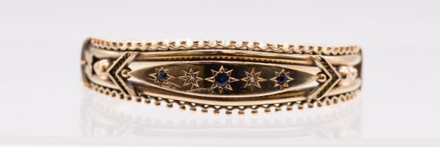 A Victorian sapphire and diamond 9ct gold hinged bangle, comprising a raised central section set